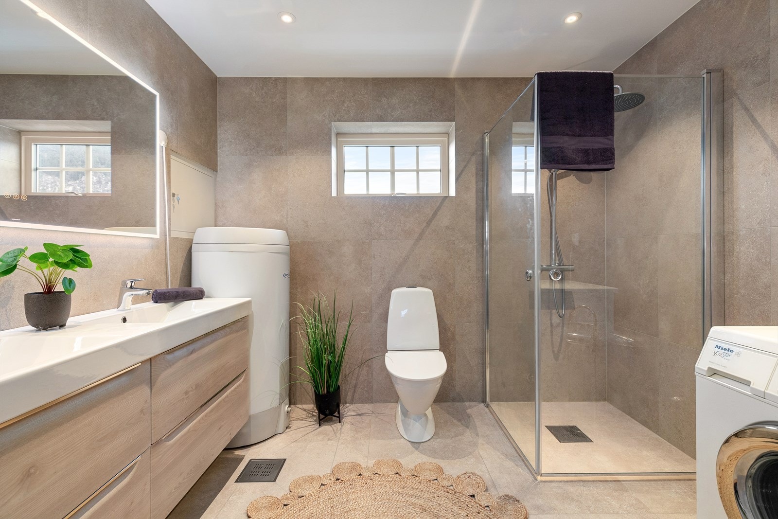 Her er det flisar og varmekablar på golv og veggar med listefri overgang til glatt himling med spotbelysning. Galleribilde