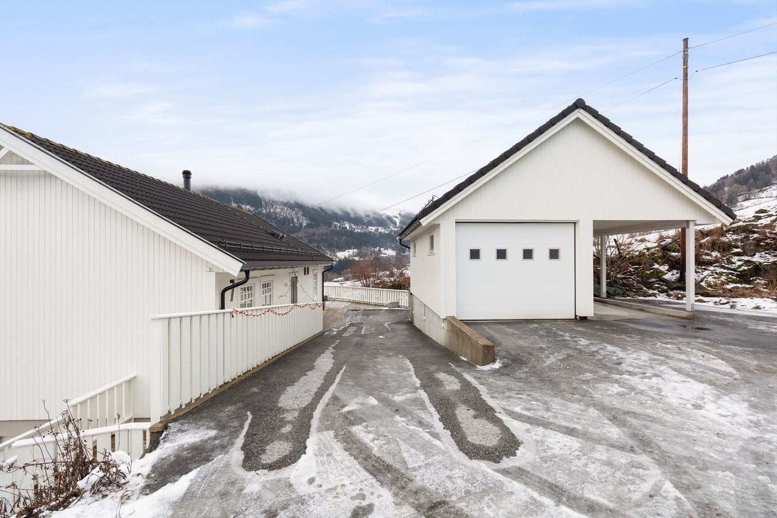 På eigedomen er det garasje med carport. Over garasjen er det gode lagringsmoglegheiter. Det er varmekablar frå parkering og ned til huset Galleribilde