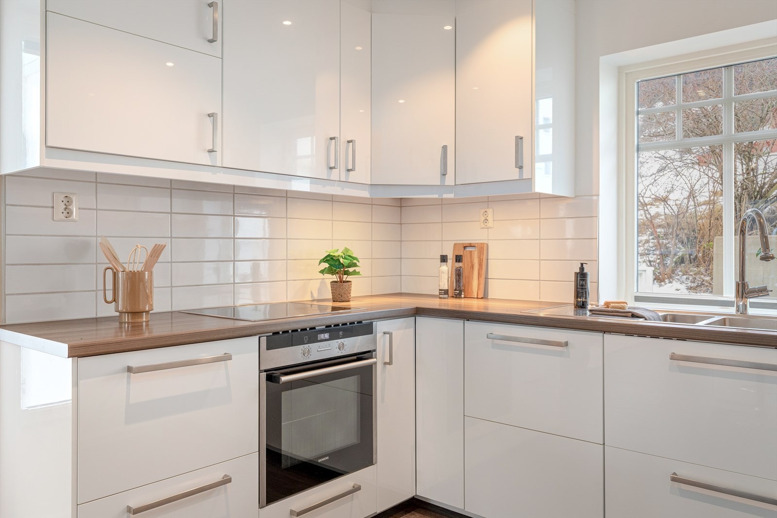 Kjøkkendelen har innreiing i kvit glatt utføring med mørk benkeplate i laminat. Galleribilde