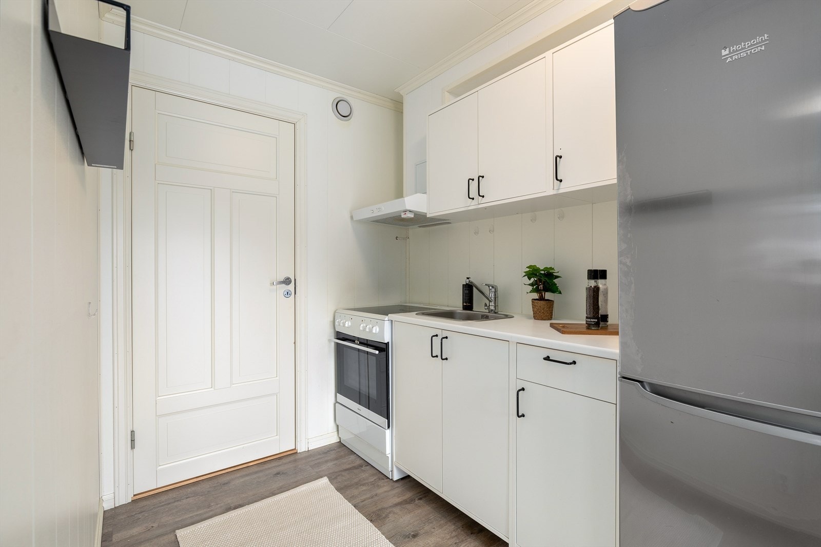 Kjøkkenet har enkel innreiing i glatt kvit utføring med benkeplate av laminat. Galleribilde