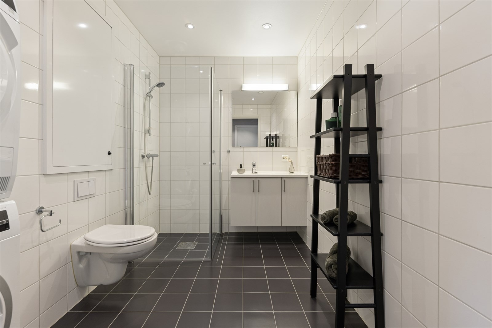 Helfliset baderom av god størrelse med vegghengt toalett, dusjhjørne, spotter i tak og god plass til vaskemaskin og tørketrommel Galleribilde