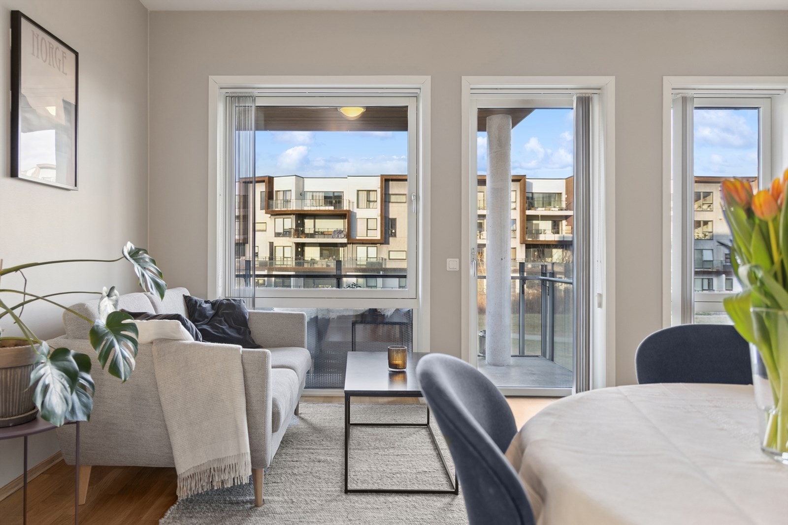 Åpen stue- og kjøkkenløsning med store vinduer og utgang til balkong Galleribilde