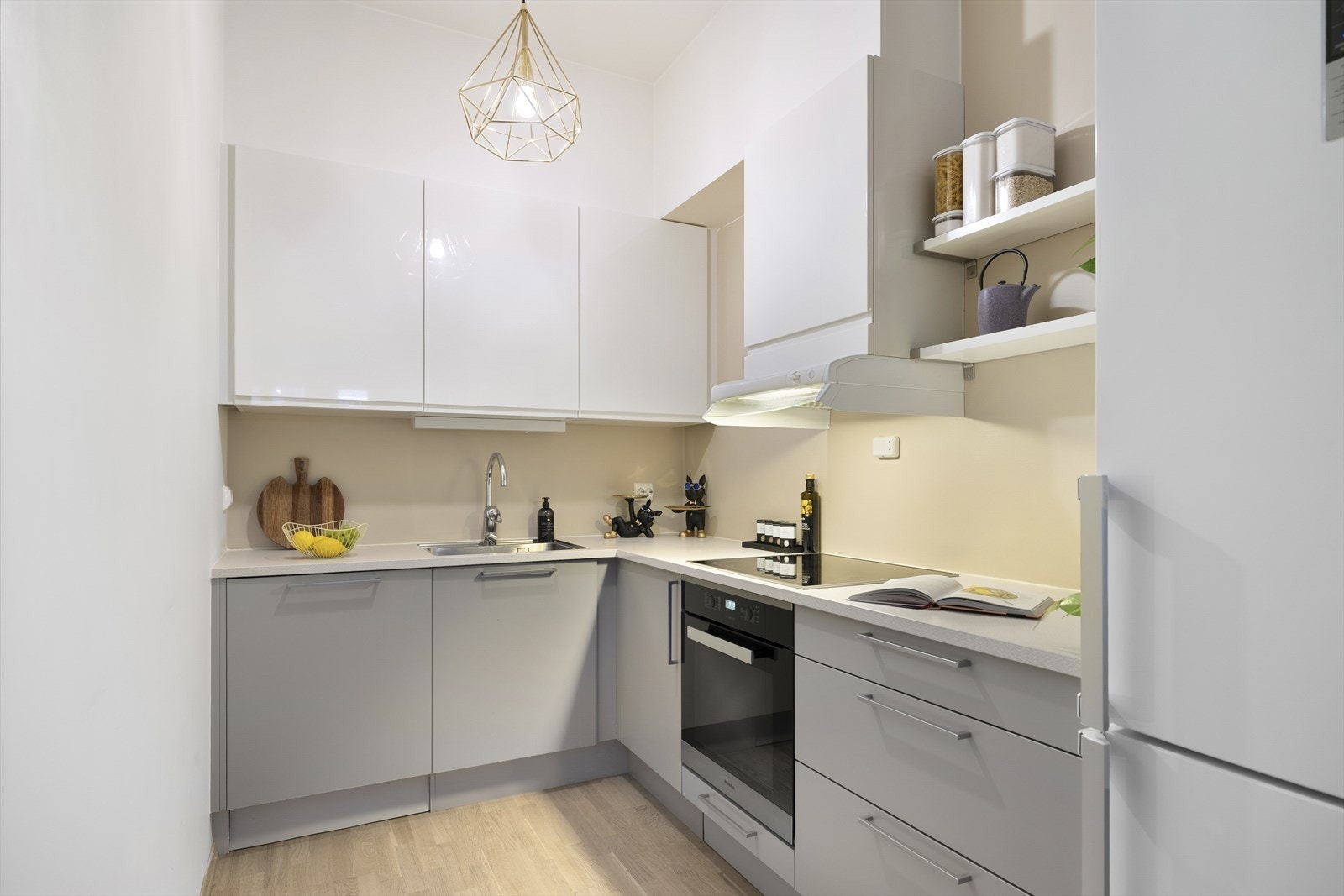 Kjøkkenet er levert av HTH og fremstår stilrent med hvite og grå slette fronter samt en praktisk laminatbenkeplate. Galleribilde