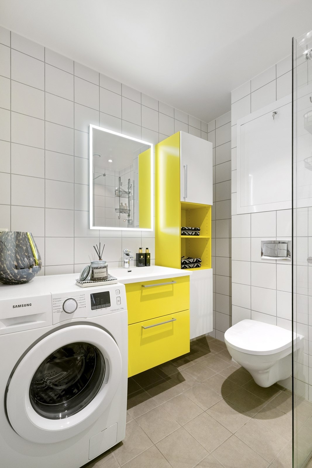 Her finner du vegghengt baderomsmøbel med servant, vegghengt toalett, dusjhjørne og opplegg for vaskemaskin. Galleribilde