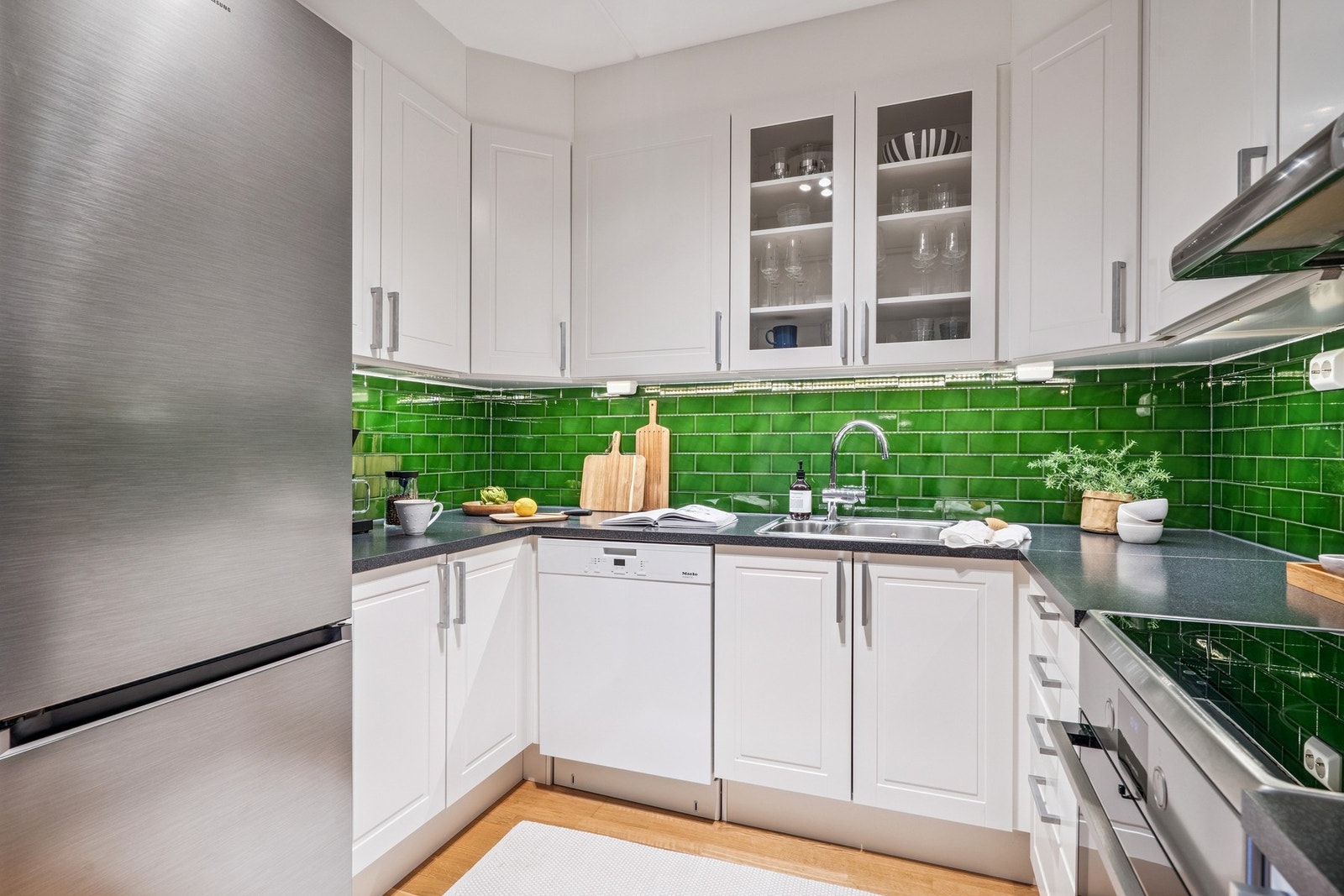 Stilrent og moderne kjøkken med friske grønne fliser som skaper et lekkert blikkfang. Galleribilde