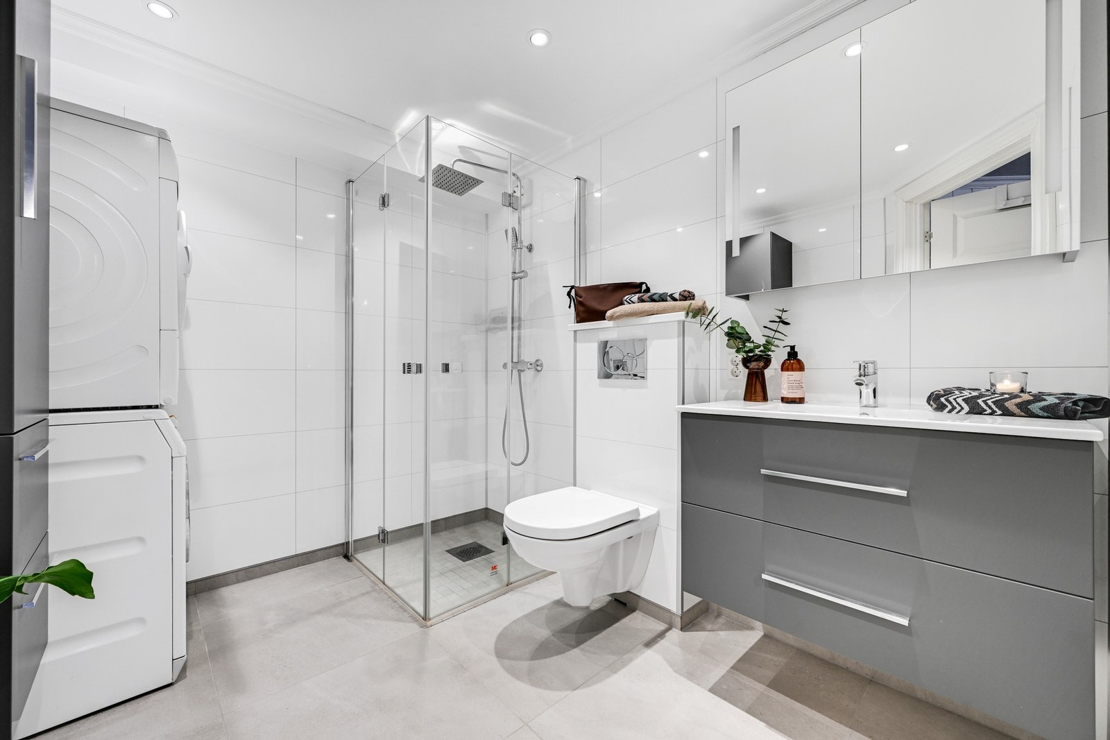 Lekkert baderom med baderomsplater på vegg, malt tak med innfelte spotter, samt flislagt gulv med elektriske varmekabler Galleribilde