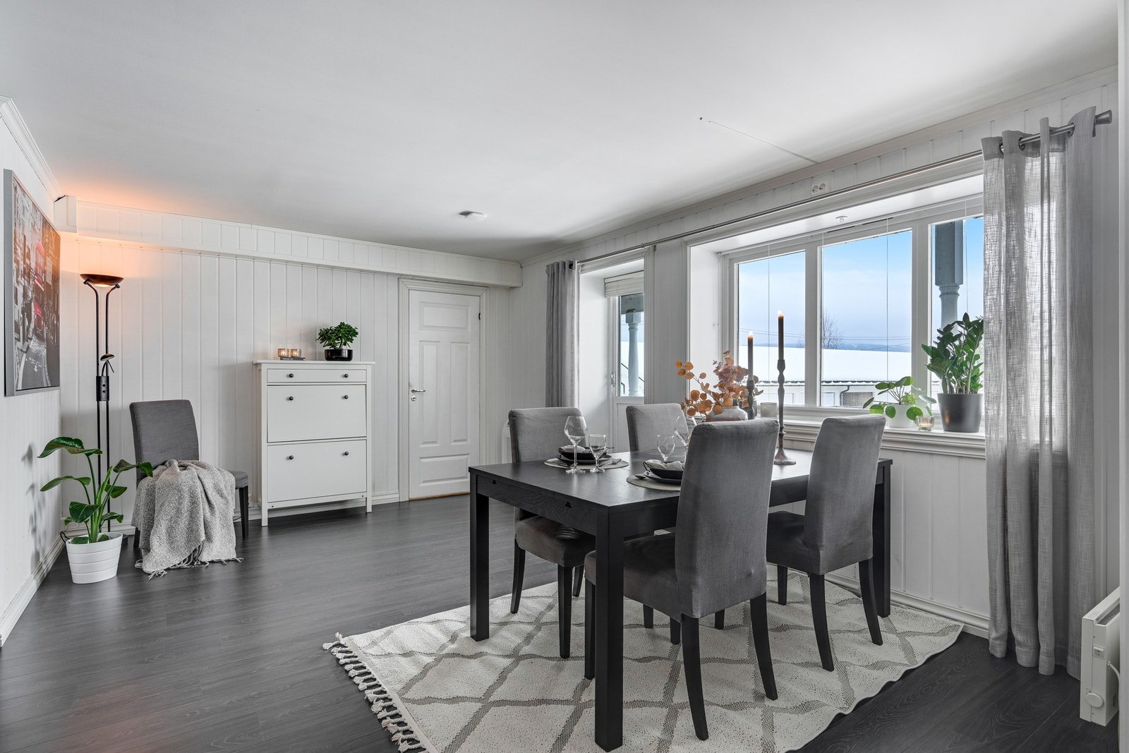 Stuen fremstår som lys og trivelig med mye lysinnslipp fra vinduene. Det er hvite vegger og tak, samt et mørkere laminatgulv Galleribilde