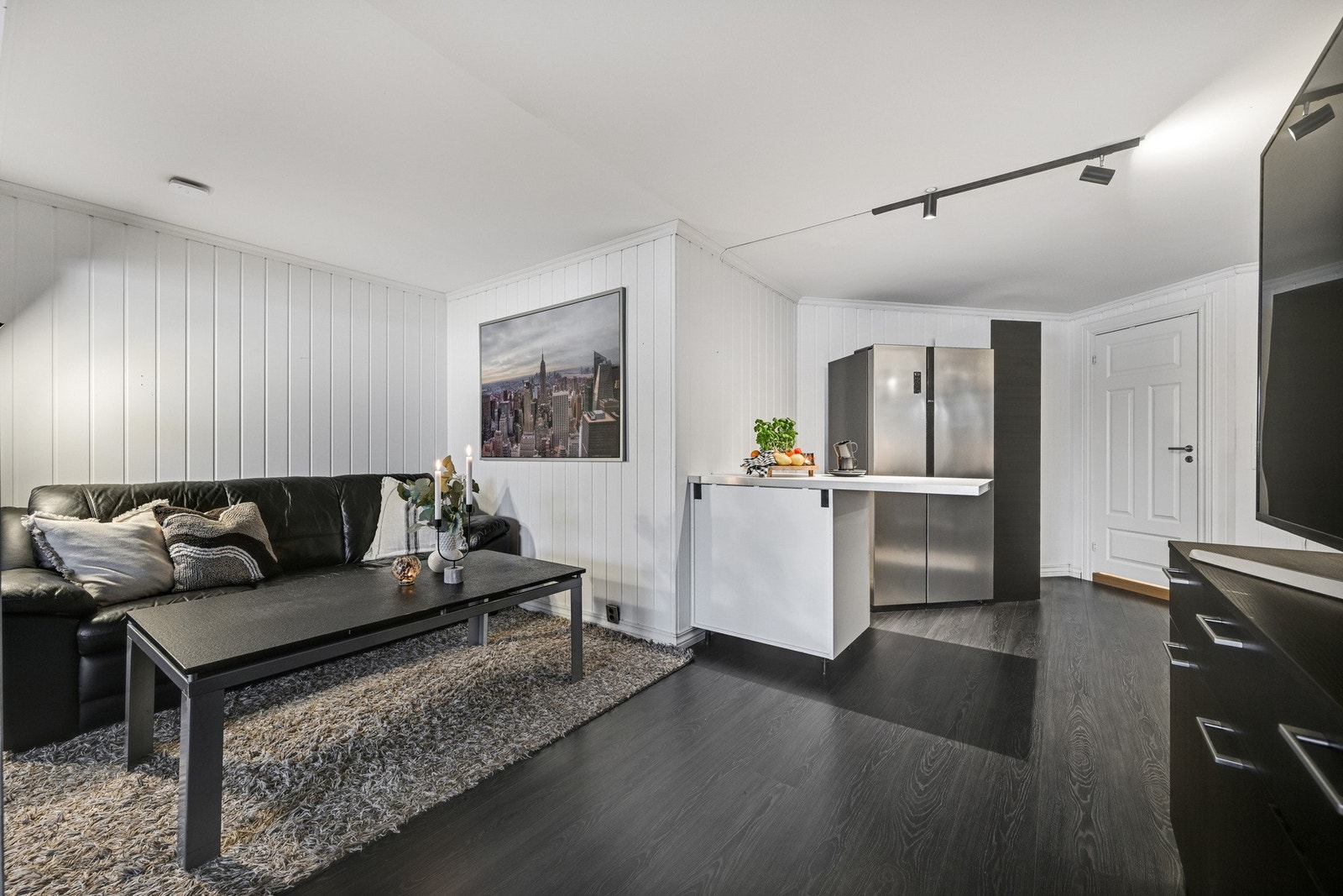 Stuen er i åpen løsning med det oppussede kjøkkenet Galleribilde