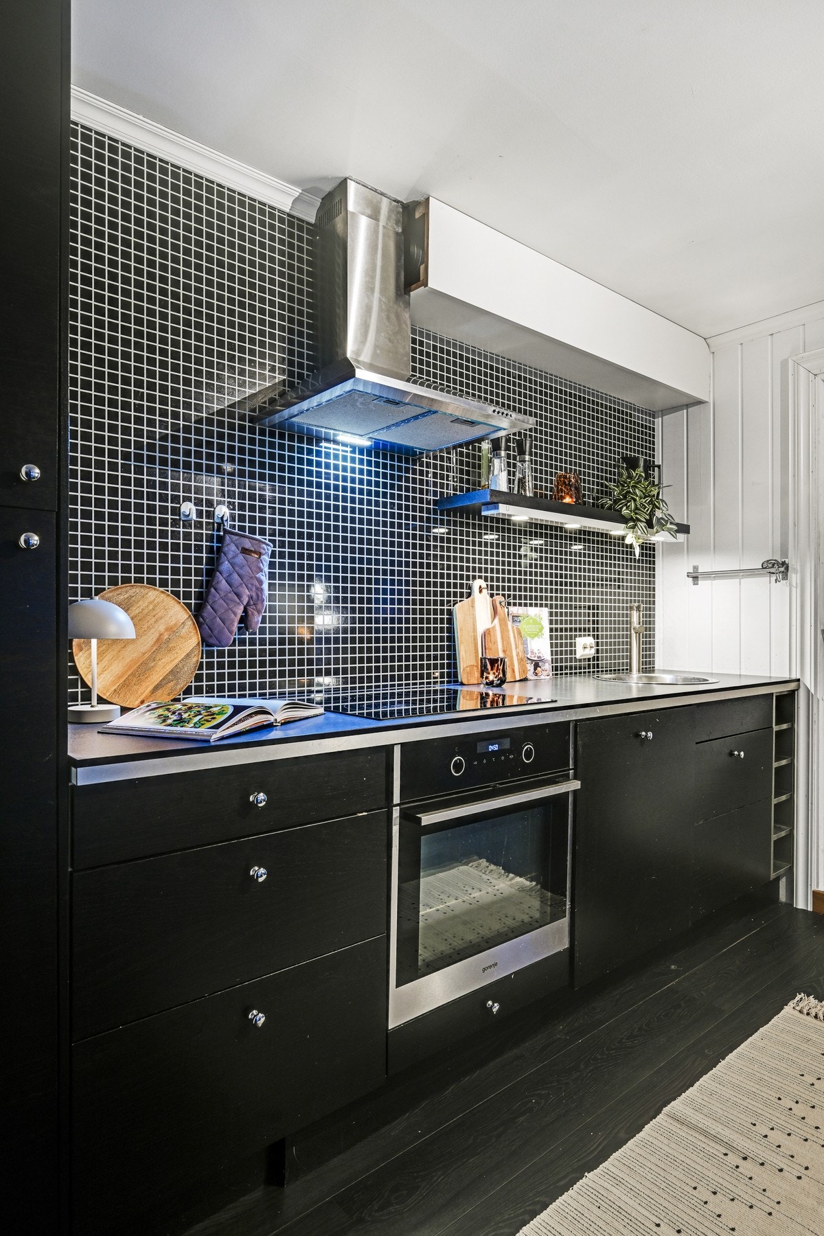 Det er innredning av glatte fronter, benkeplate av laminat og en ventilator som sørger for avtrekk ut Galleribilde