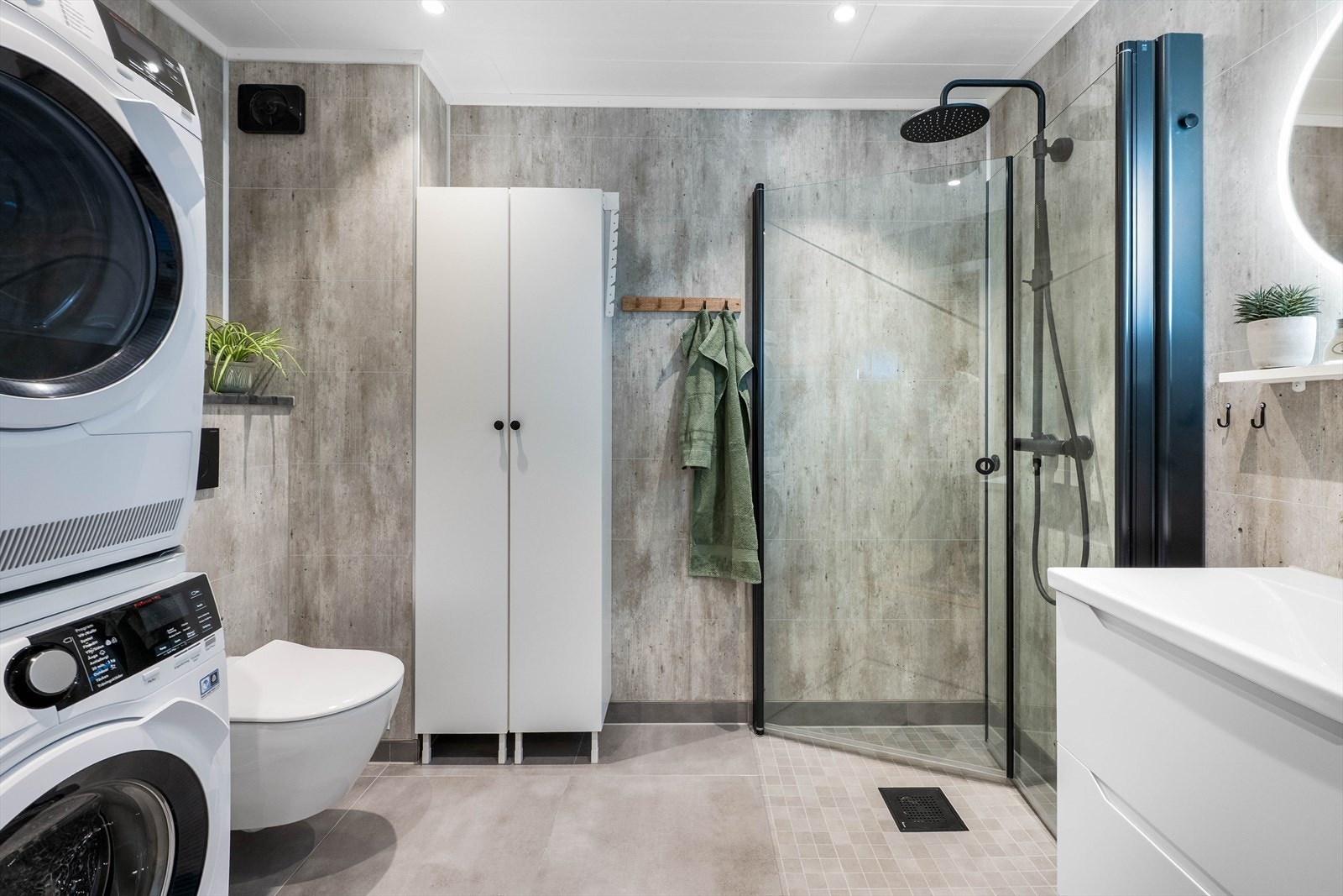 Flislagt gulv og baderomsplater på vegger. Det er elektriske varmekabler i gulvet som gir komfort og funksjonalitet. Galleribilde