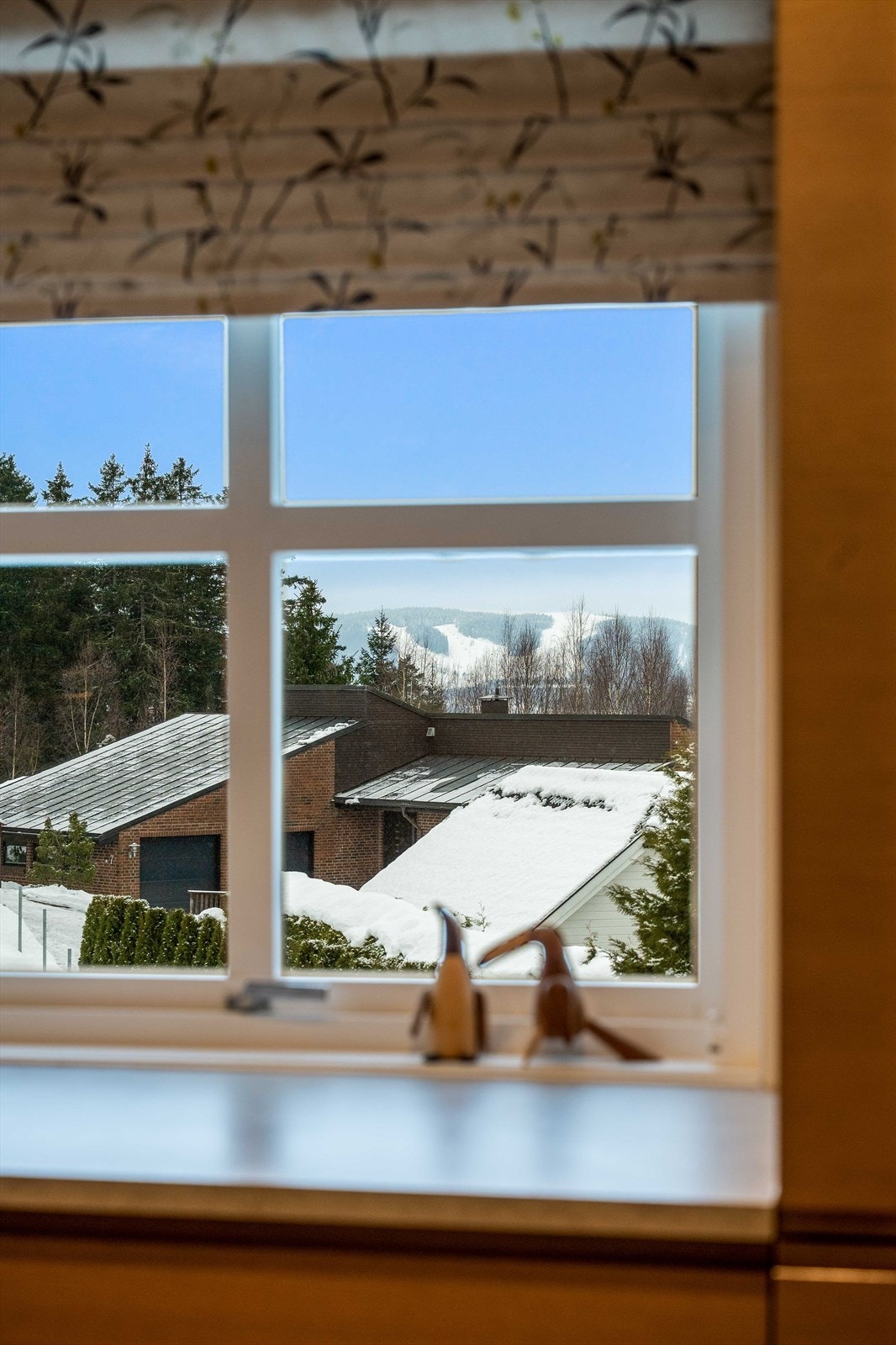 Store vinduer gir utsikt mot omkringliggende natur fra kjøkkenet. Galleribilde