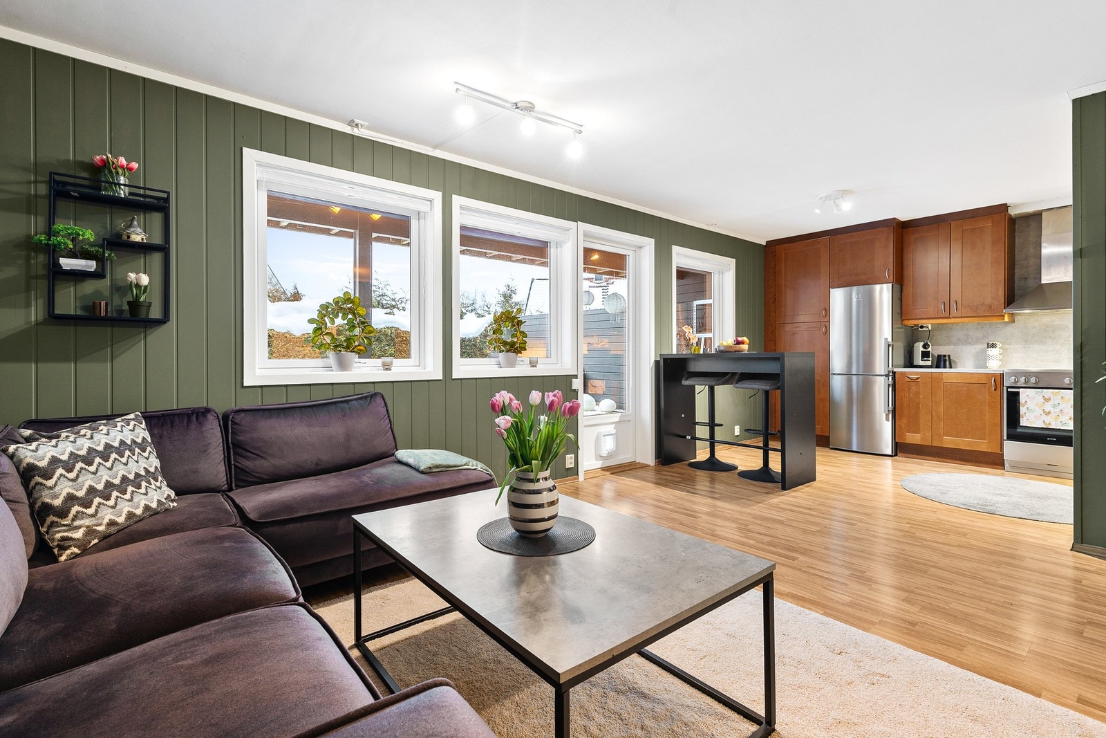 Lys og innbydende stue med åpen kjøkkenløsning og fin plass til sofa, tv-møblement og spisebord Galleribilde