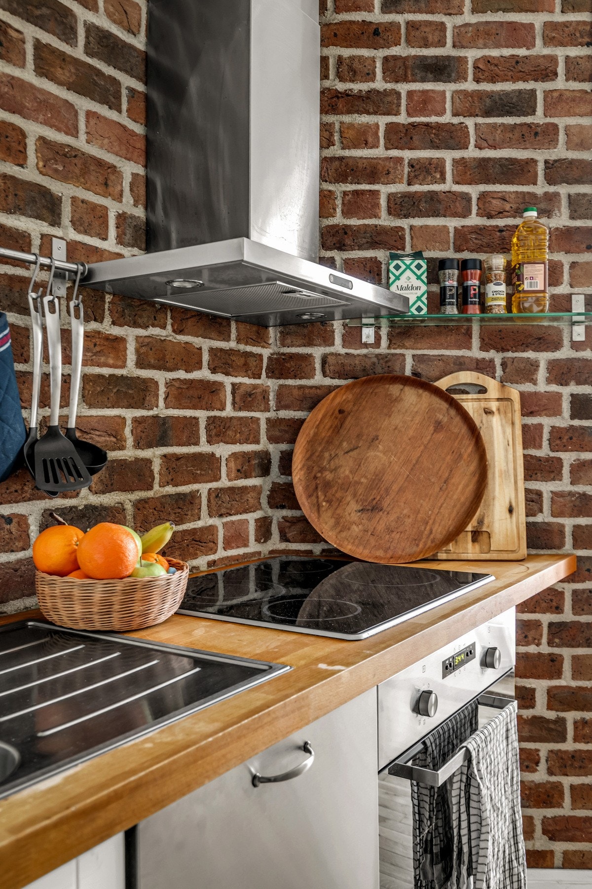 Karakterfull teglsteinsvegg gir kjøkkenet et unikt og urbant preg, som skaper kontrast til de lyse overflatene og tilfører boligen særpreg. Galleribilde