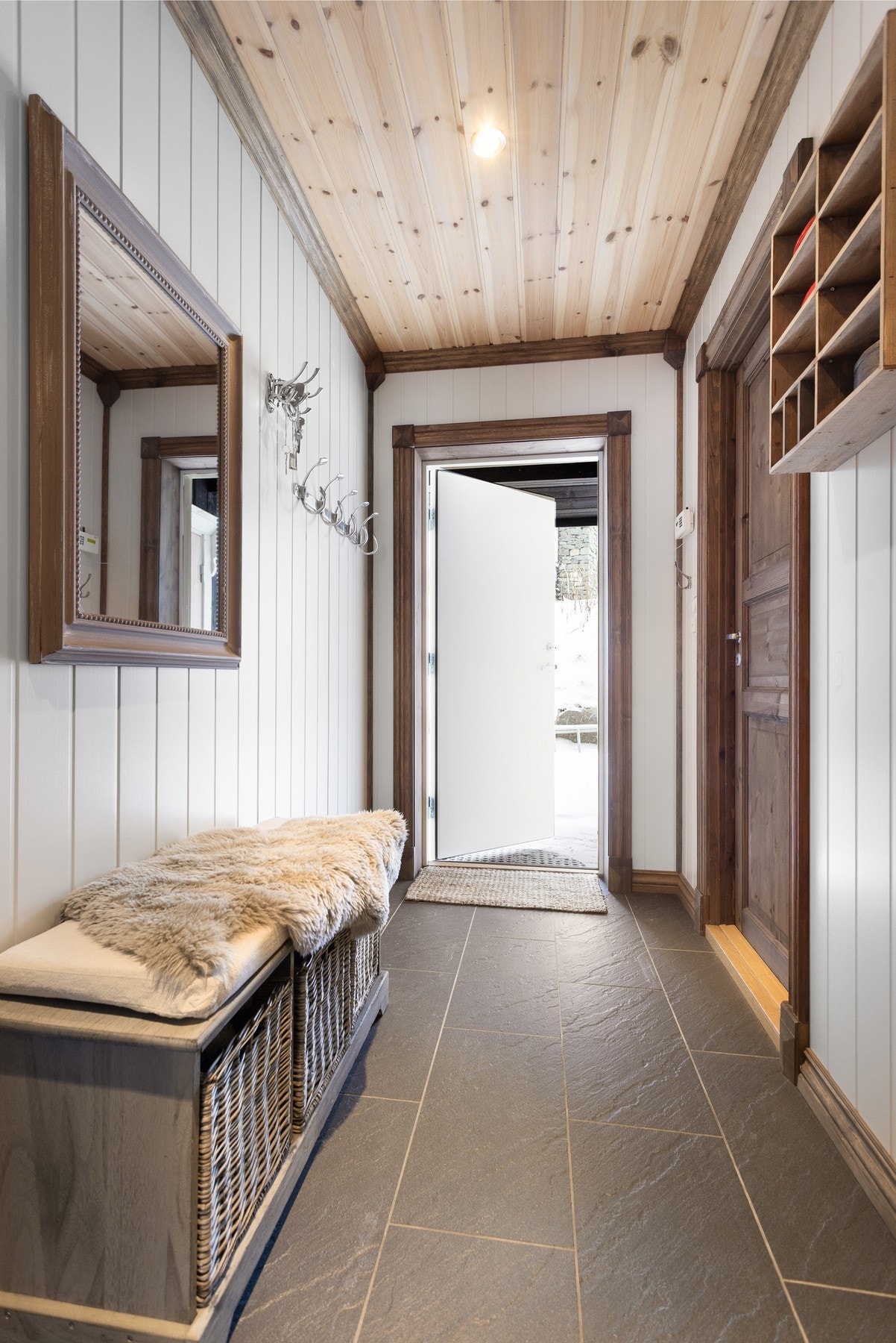 Innbydende entré med god plass til å henge fra seg yttertøy. Flislagt gulv med varmekabler bidrar til en varm velkomst Galleribilde