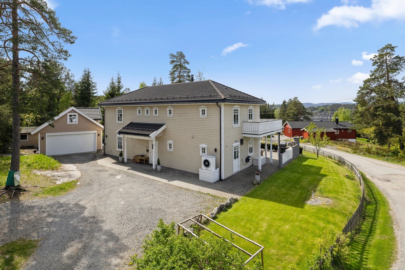 Romslig tomt som er pent opparbeidet med plenarealer, diverse beplantning, steinlagte arealer, terrengtilpasset trapp og fine uteplasser. Gruslagt gårdsplass med dobbelgarasje samt godt med biloppstillingsplasser på egen eiendom. Galleribilde