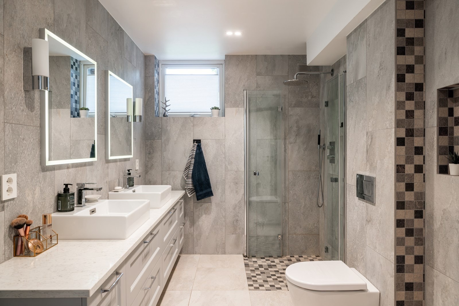 Lekkert flislagt bad i underetasjen fra 2019 innredet med dusjnisje, vegghengt toalett og doble servanter Galleribilde