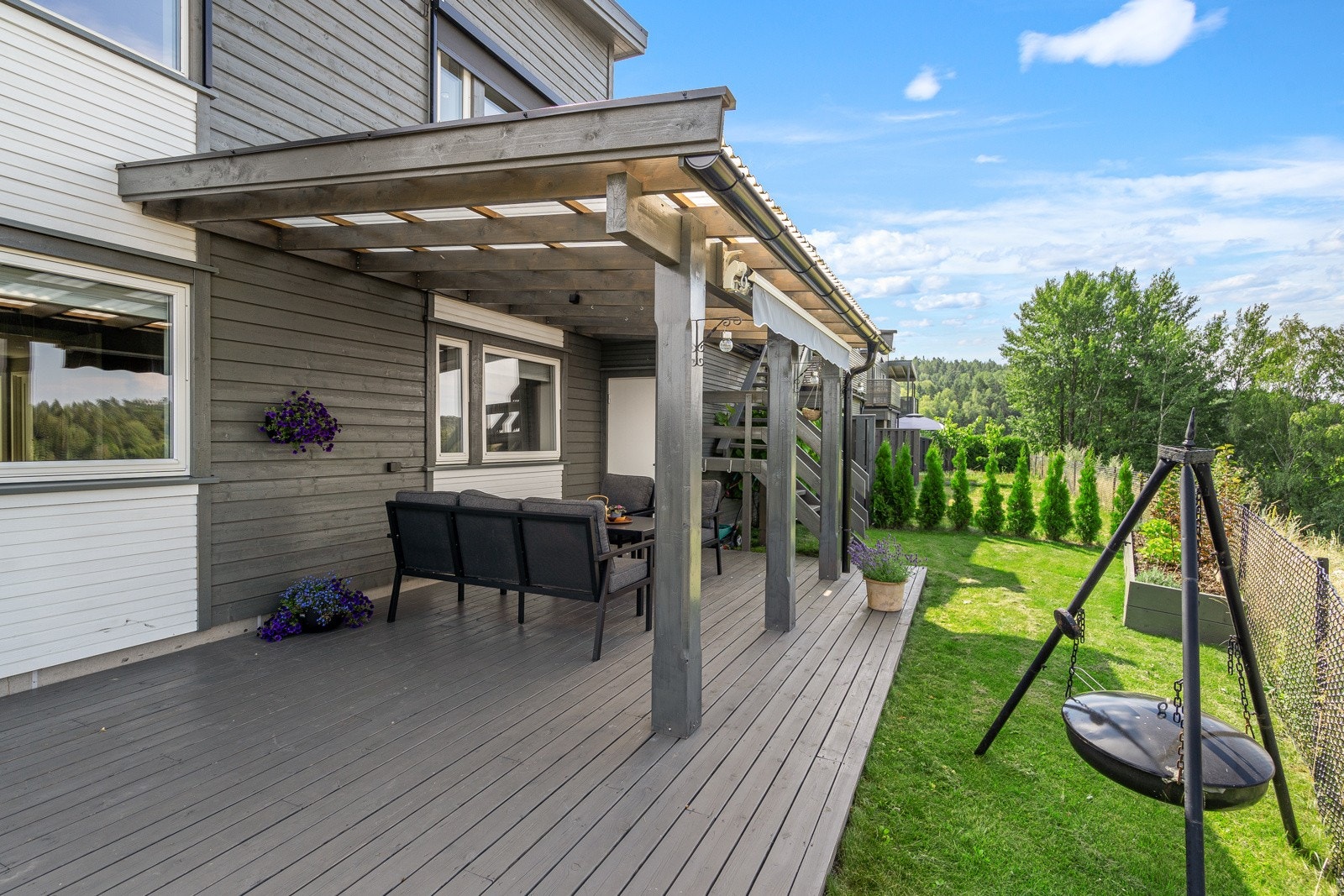 Fra balkongen fører en trapp deg ned til en koselig terrasse på bakkenivå med overbygg av solide glassfiberplater - ideelt for å nyte utelivet også på dager med litt regn. Galleribilde