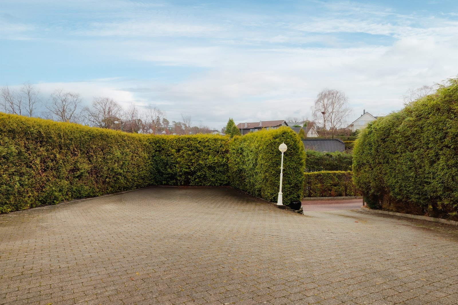 Stor og usjenert uteplass med mange parkeringsplasser. Varmekabler i innkjørsel. Galleribilde