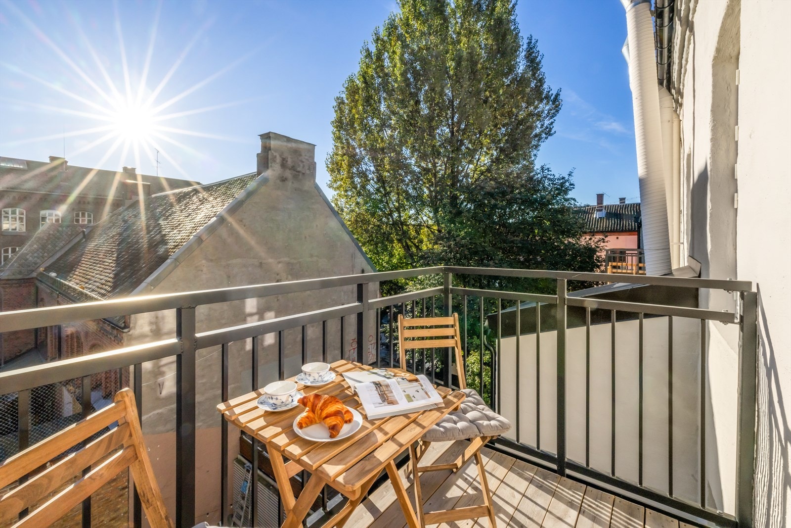 Utsikt fra balkongen gir et godt overblikk over nærområdet, med sollys som skinner inn. Galleribilde