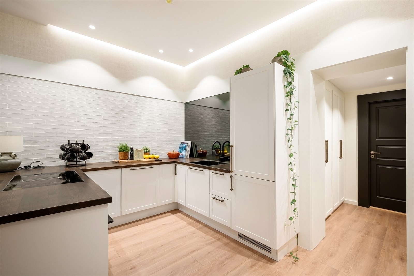 Integrert i kjøkkeninnredningen er komfyr, kjøl/frys, oppvaskmaskin, og induksjonstopp med kullfilterventilator. Galleribilde