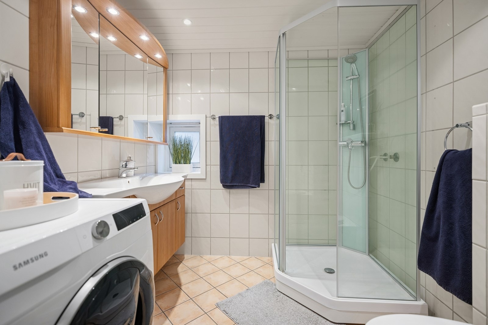 Dusjkabinett fra 2020 og opplegg til vaskemaskin gir funksjonell bruk av våtrommet. Galleribilde