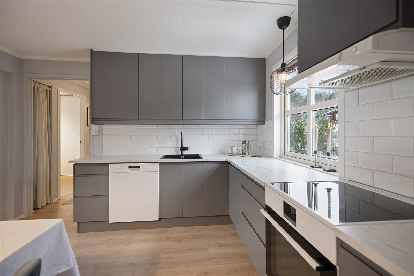 Laminat benkeplate og pene fliser mellom benk og overskap gir et ryddig kjøkkenområde. Galleribilde