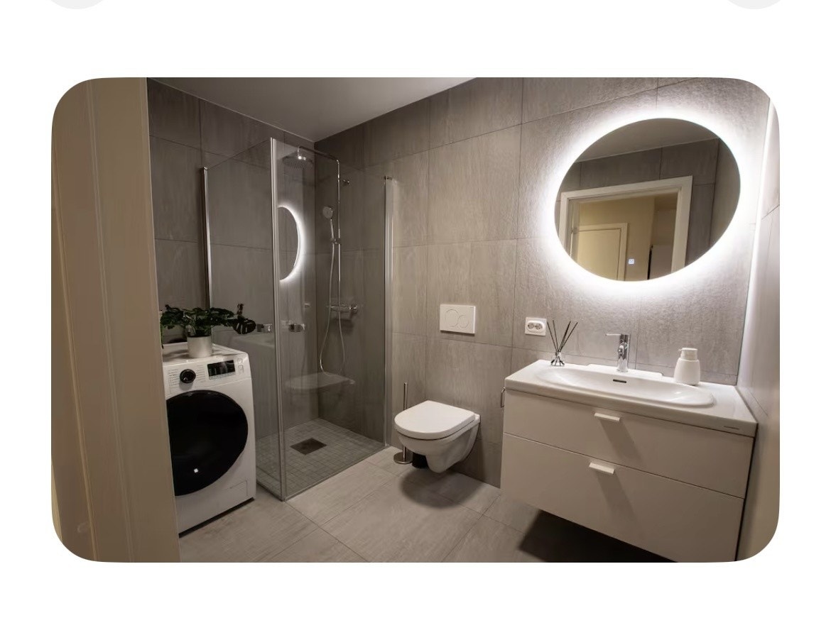Bad med dusjhørne og kombinert vaskemaskin/tørketrommel Galleribilde