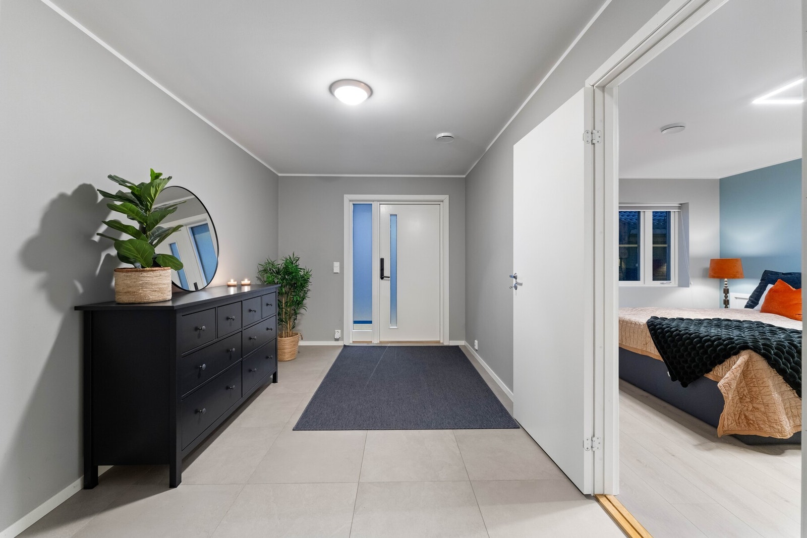 Boligen ønskes velkommen via en romslig og praktisk entré med gode oppbevaringsmuligheter for yttertøy og sko. Entréen gir et ryddig førsteinntrykk og fungerer som et naturlig bindeledd videre inn i boligen. Galleribilde