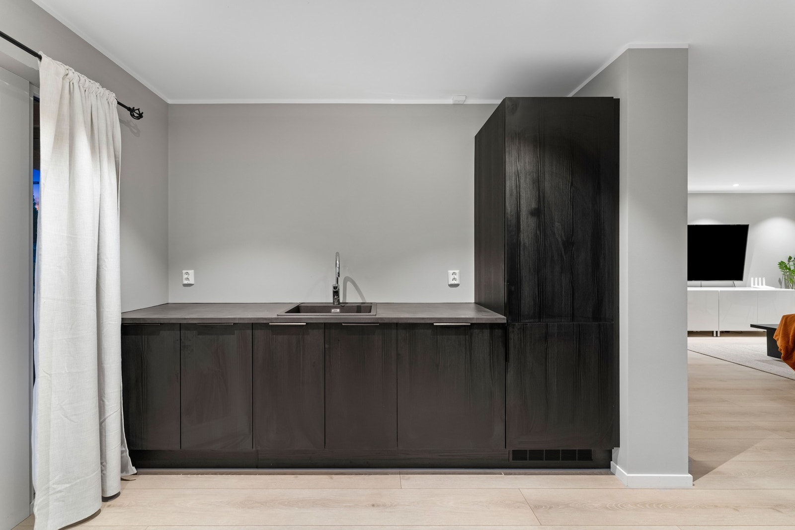 Kjøkkenløsningen strekker seg langs to vegger, i tillegg til en barløsning som passer godt for både daglig bruk og matlaging i større sammenhenger. Galleribilde