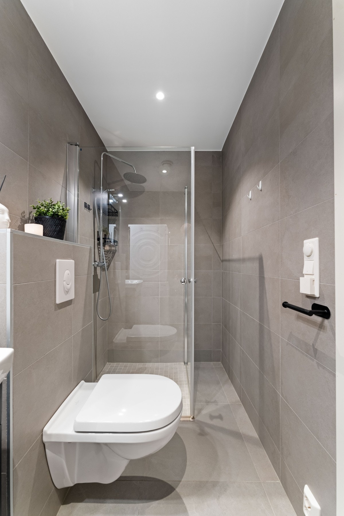 Badet i underetasjen er oppgradert og har flislagte overflater. Rommet er utstyrt med dusjløsning med glassdører, servant, vegghengt toalett samt opplegg for vaskemaskin. Galleribilde