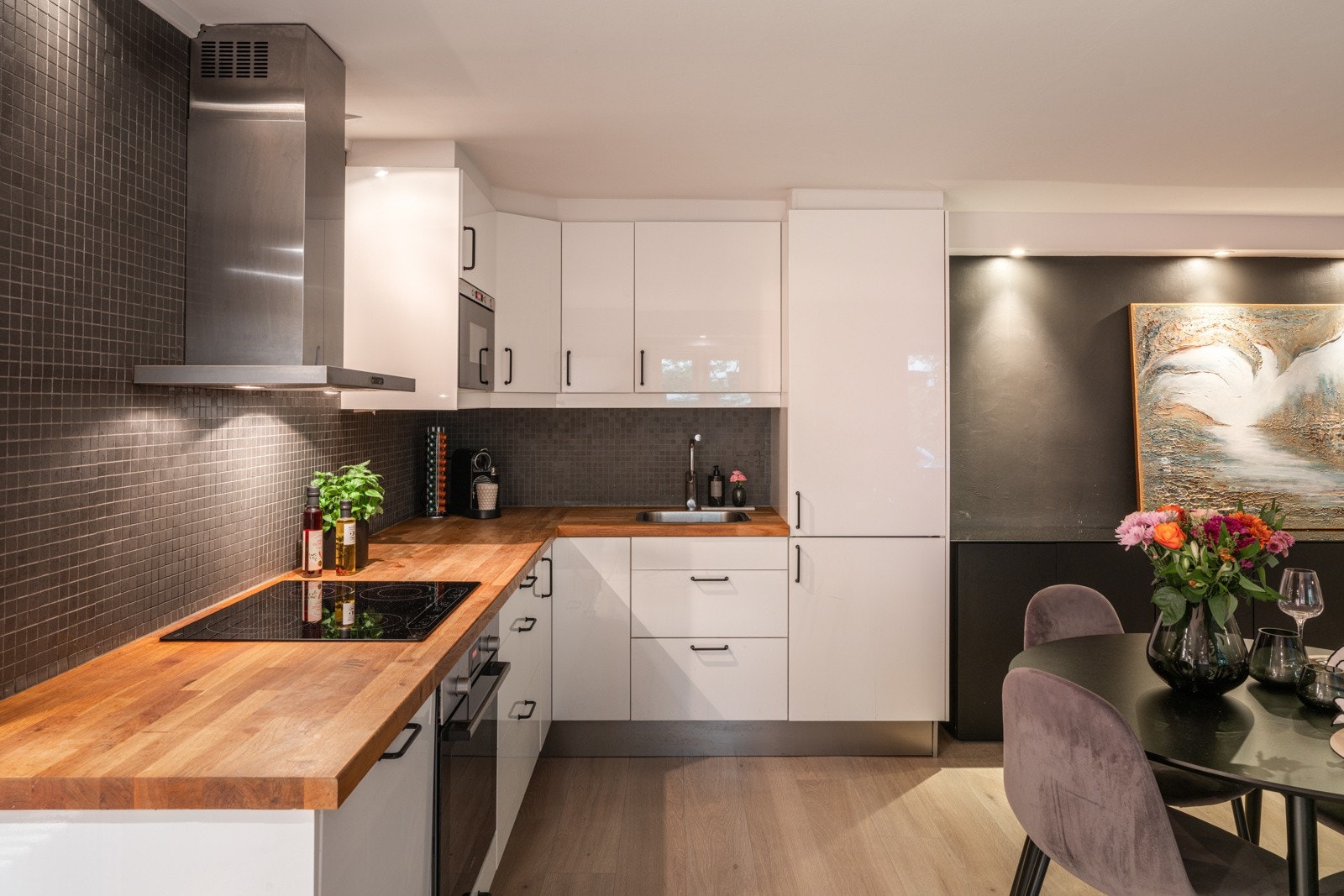 Stilren kjøkkeninnredning med glatte fronter og benkeplate av heltre Galleribilde