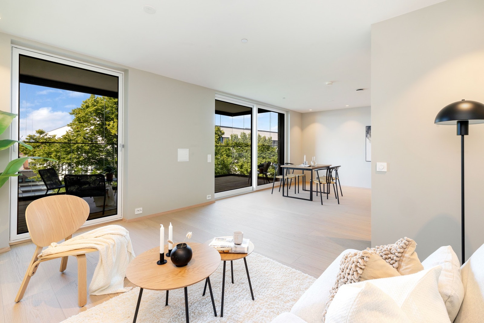 Lys og fin stue med åpen løsning mot kjøkken og utgang til innglasset balkong Galleribilde