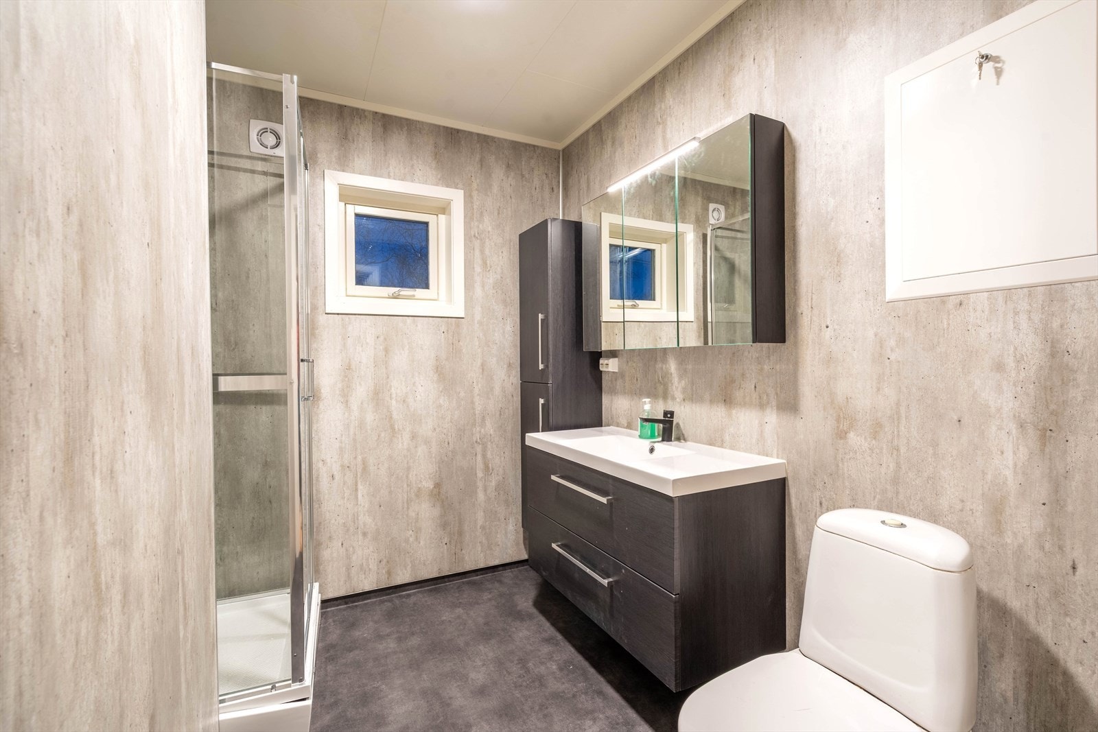 Moderne bad med stilrene overflater, dusjkabinett og praktisk oppbevaringsplass. Elegant design som gir en følelse av romslighet og komfort. Galleribilde