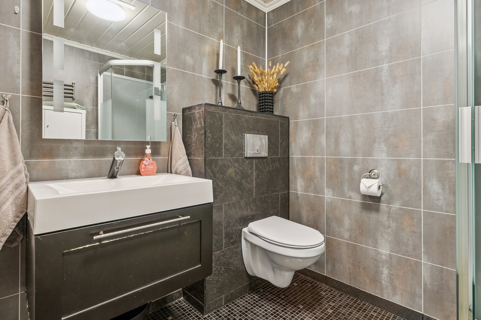 Baderommet er utstyrt med vegghengt servantinnredning, vegghengt toalett og dusjkabinett. Galleribilde