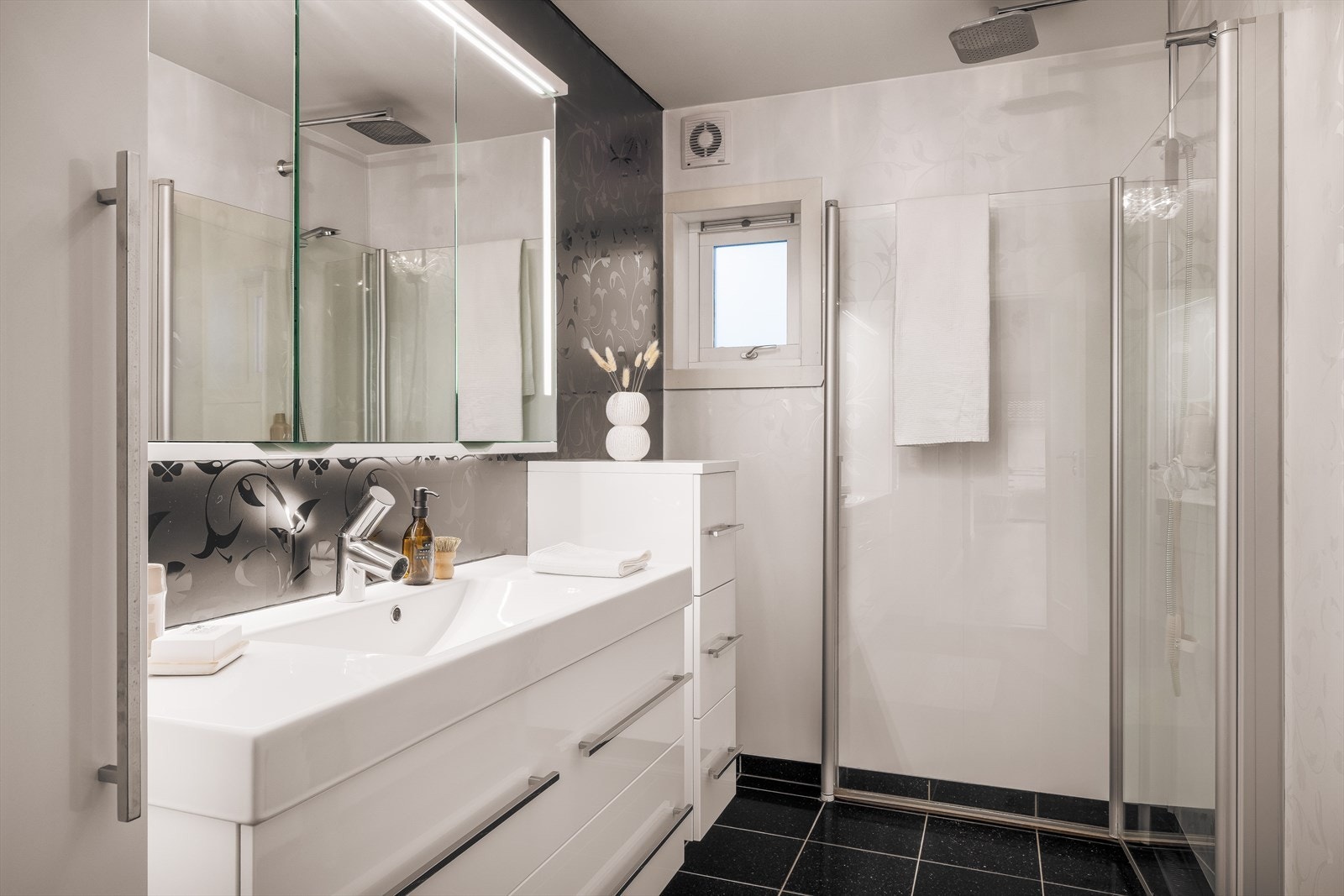 Badet har flislagt gulv og veggene har baderomsplater. Galleribilde