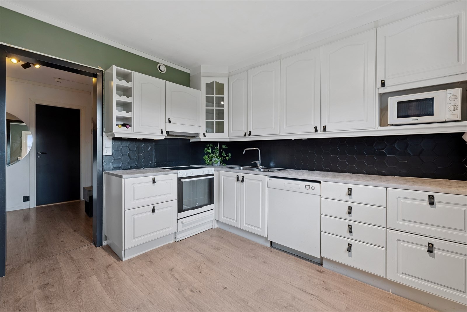 Kjøkkenet har en hvit profilert innredning og godt med benkeplass. Galleribilde