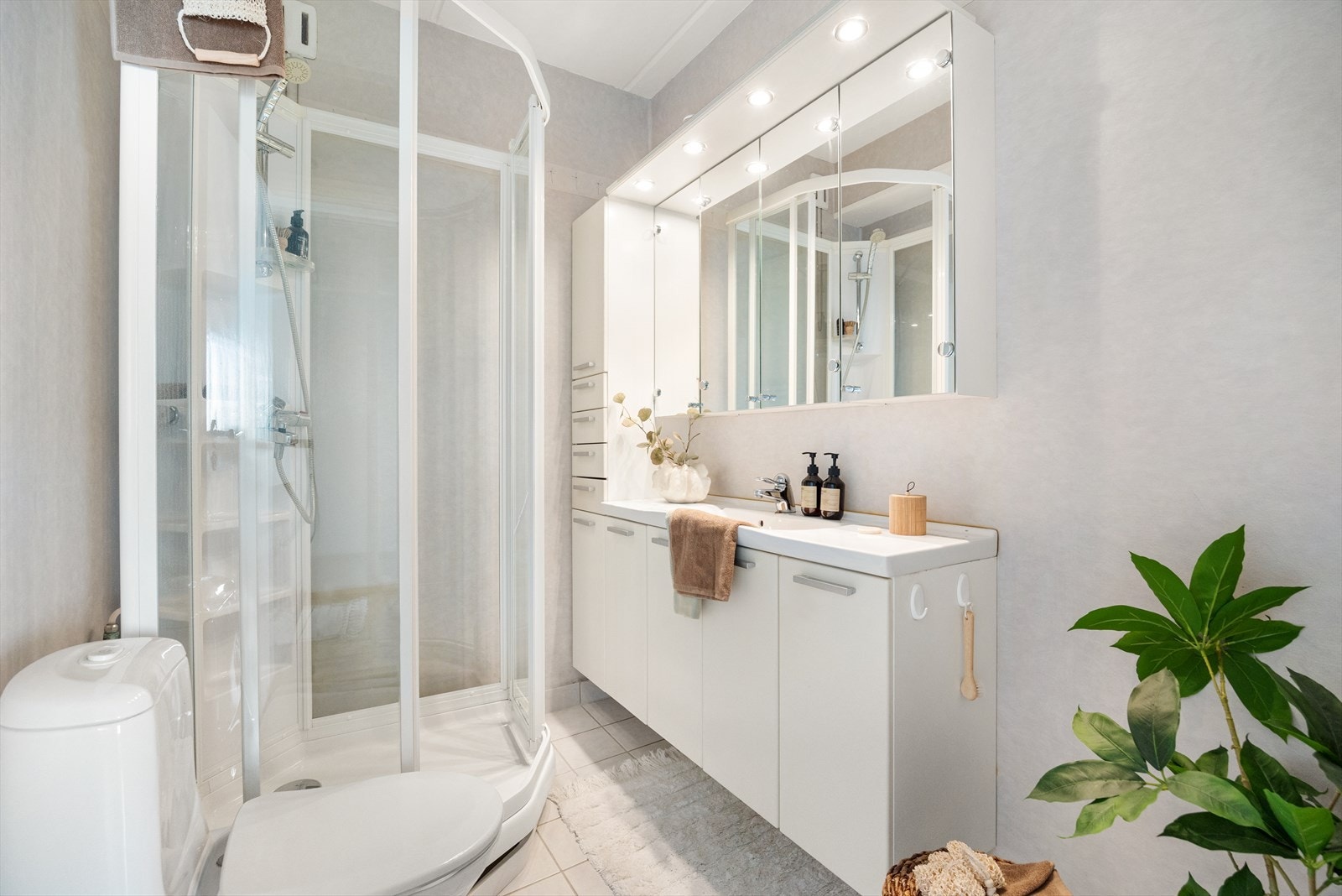 Badet har baderomstapet på vegger og malt betonghimling samt helfliset gulv med gulvvarme Galleribilde