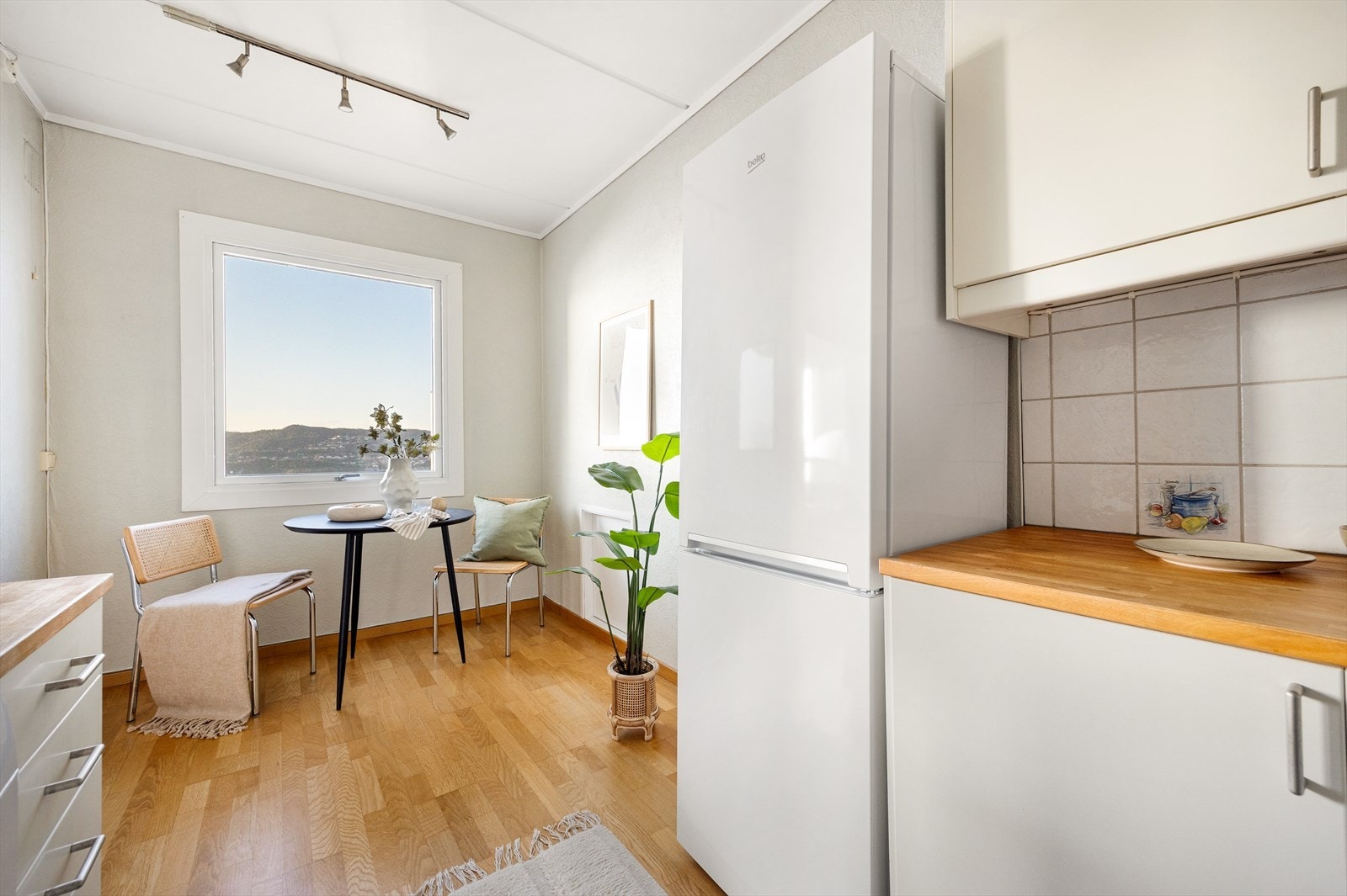 Kjøkkenet har slette fronter, benkeplate av heltre og fliser på veggene over benkeplaten. Galleribilde