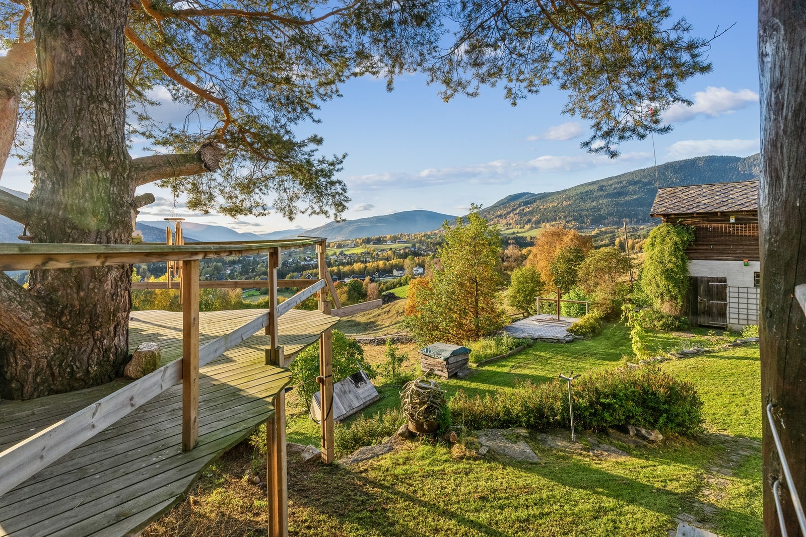 Hovedbygningen: Fra verandaen kan man gå ut til en utvidet del av verandaen, som er bygget rundt et av furutrærne
på eiendommen Galleribilde