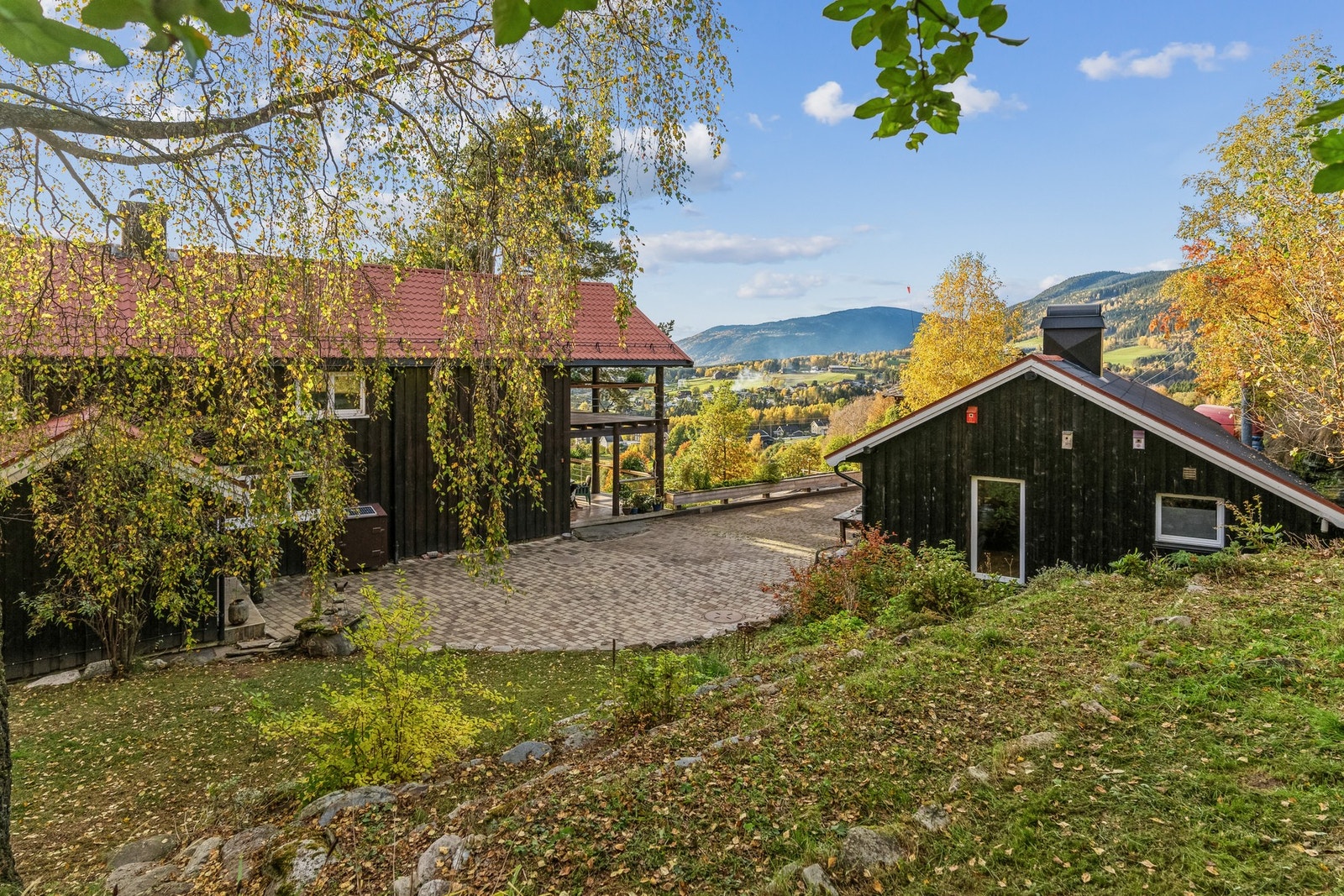 Koselig tun hvor gårdsplassen med belegningsstein omkranses av hovedbygningen og annekset. Galleribilde