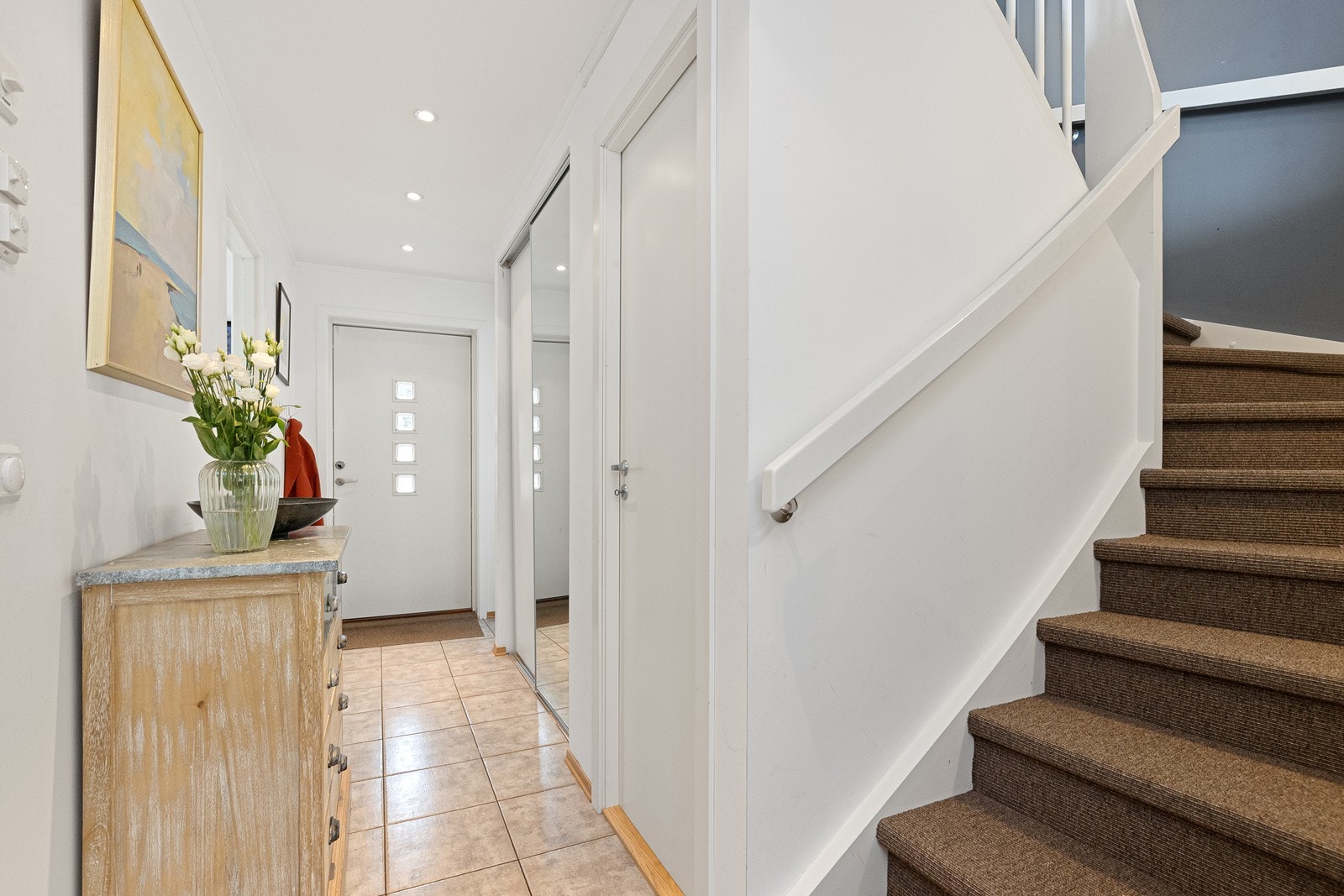 Velkommen inn! Flislagt entré/gang med integrert skyvedørsgarderobe og ekstra bod under trappegang. Galleribilde