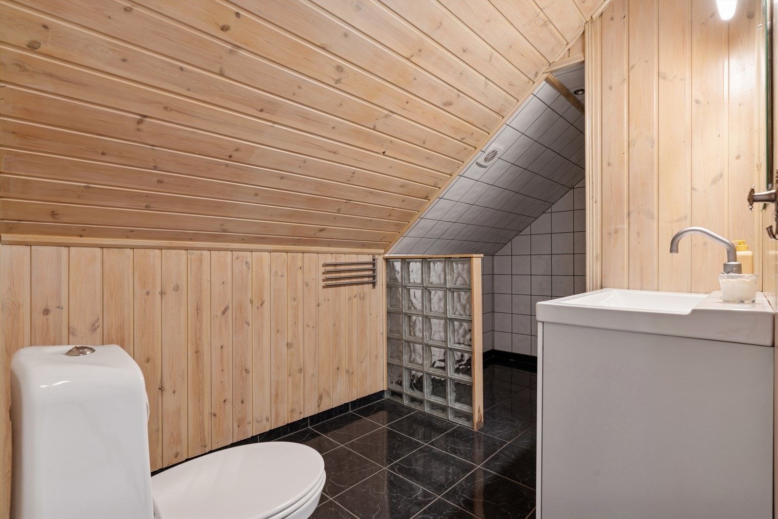 Rommet har dusj, toalett og seksjon med servant. Elektrisk vifte i himlingen. Vifte fungerer ikke og er ikke tilkoblet strøm. Deler av loft har ikke målbart areal på skråtak og takhøyde under 1.90 meter. Galleribilde