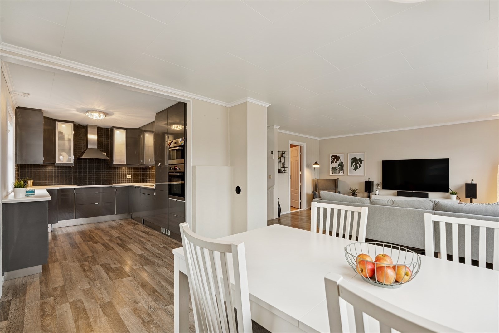 Tiltalende og velutstyrt kjøkken, innredning med glatte fronter og laminert benkeplate. Kjøkkenventilator over komfyr/platetopp. Galleribilde