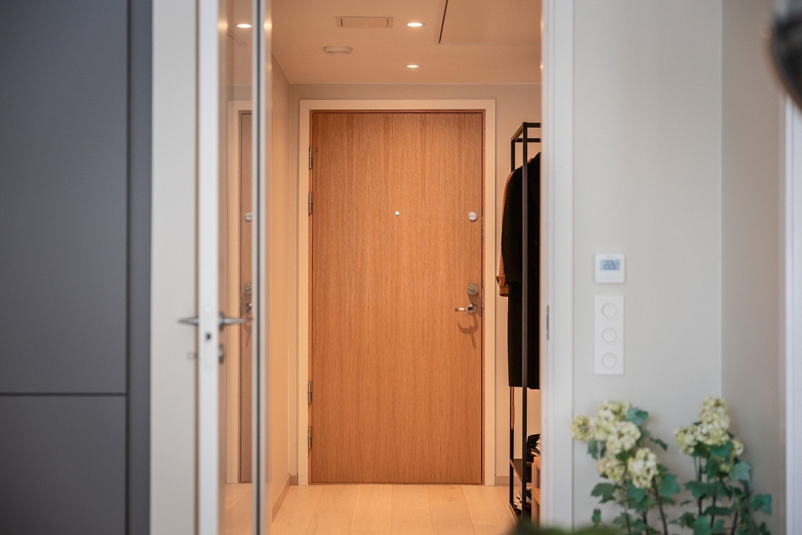 Entré med ytterdør i tre som gir et varmt og gjennomført førsteinntrykk. Galleribilde