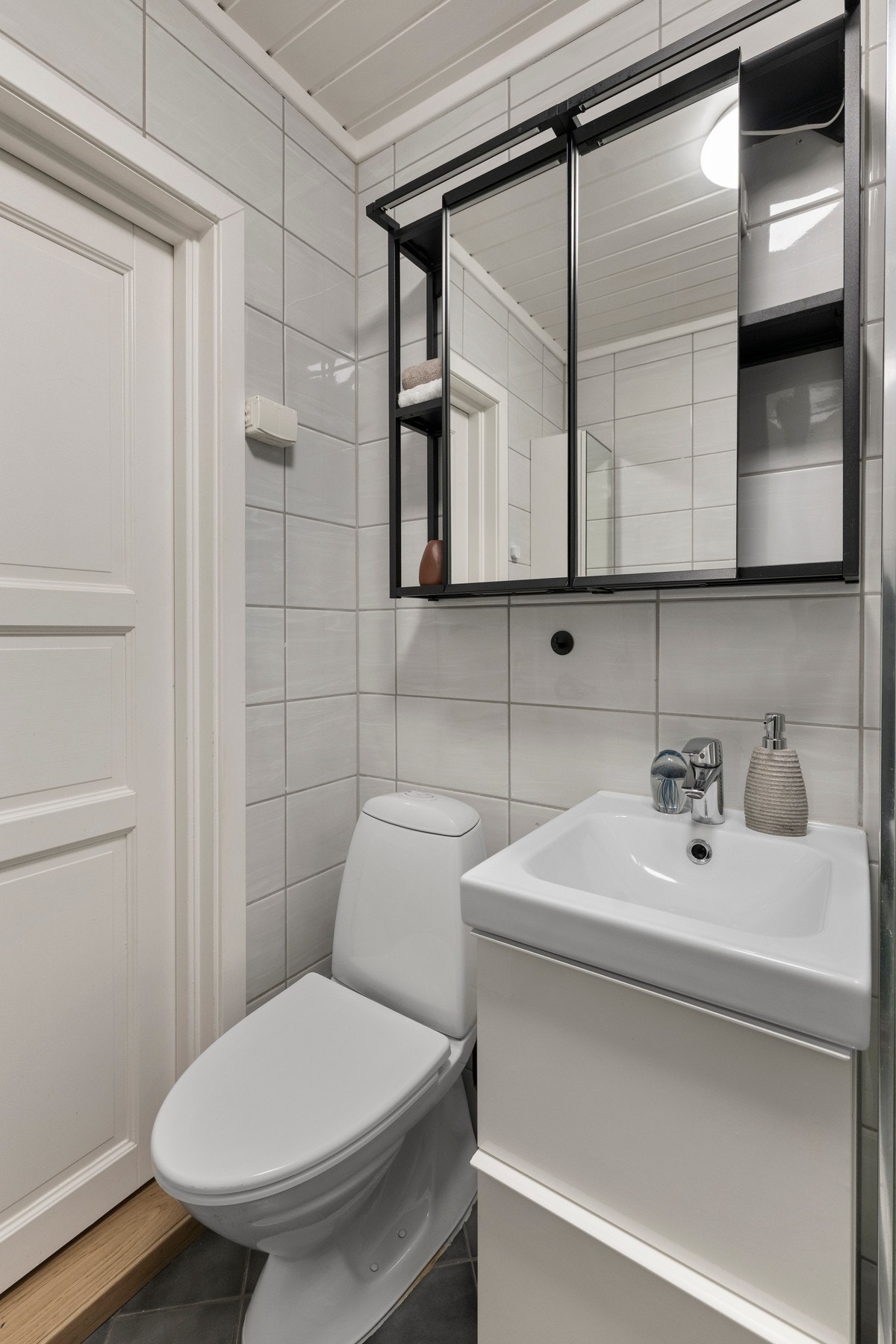 Bad/vaskerommet har opplegg for vaskemaskin, toalett, dusjkabinett i herdet glass, høyskap med speilfront, baderomsinnredning med høyglans fronter og heldekkende servant. Galleribilde