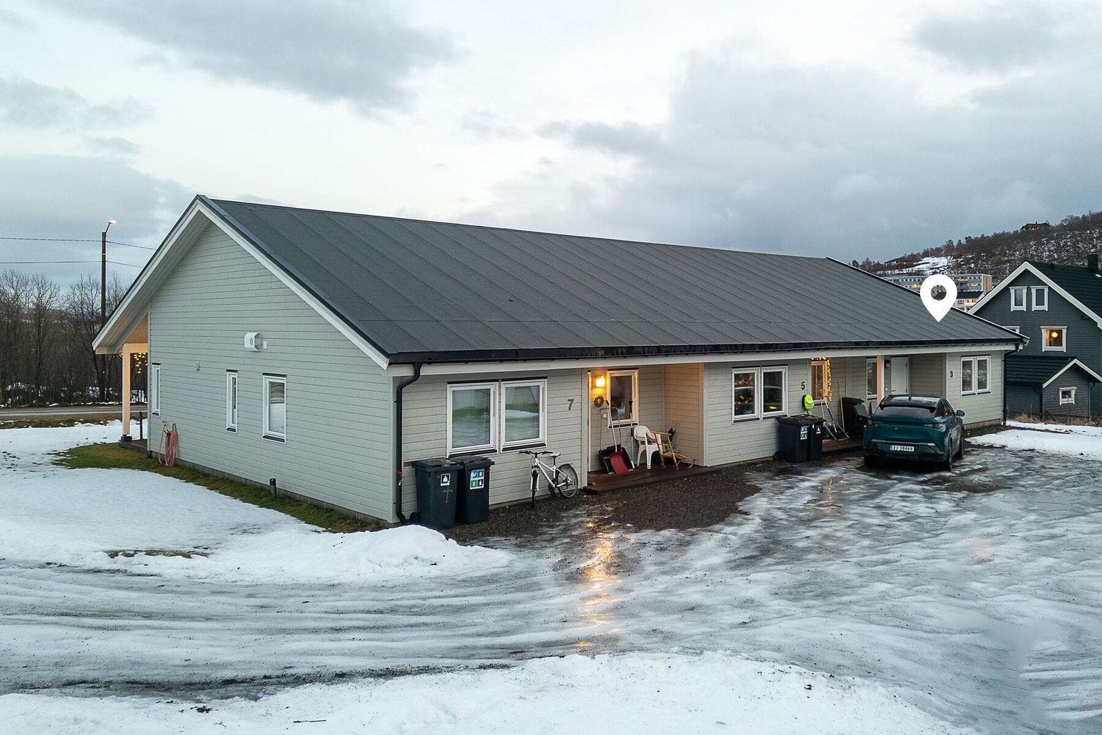 Fasade og uteområde. Det er gruset innkjørsel og gårdsplass med biloppstillingsplasser. Galleribilde