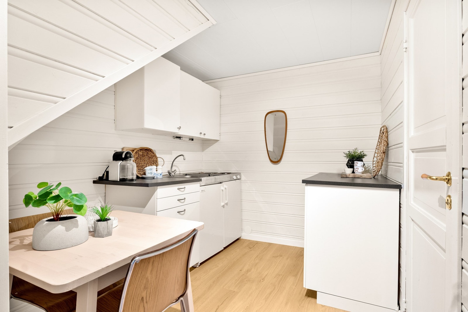 Et praktisk mini kjøkkenmodul med kjøleskap, vask og platetopp, supplert med noen skap. Galleribilde