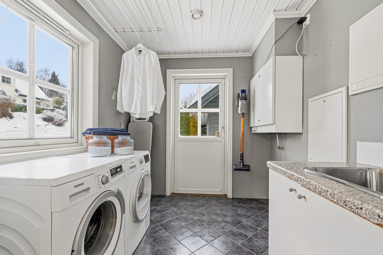 Vaskerom i hoveddel med opplegg for vaskemaskin og praktisk innredning. Galleribilde