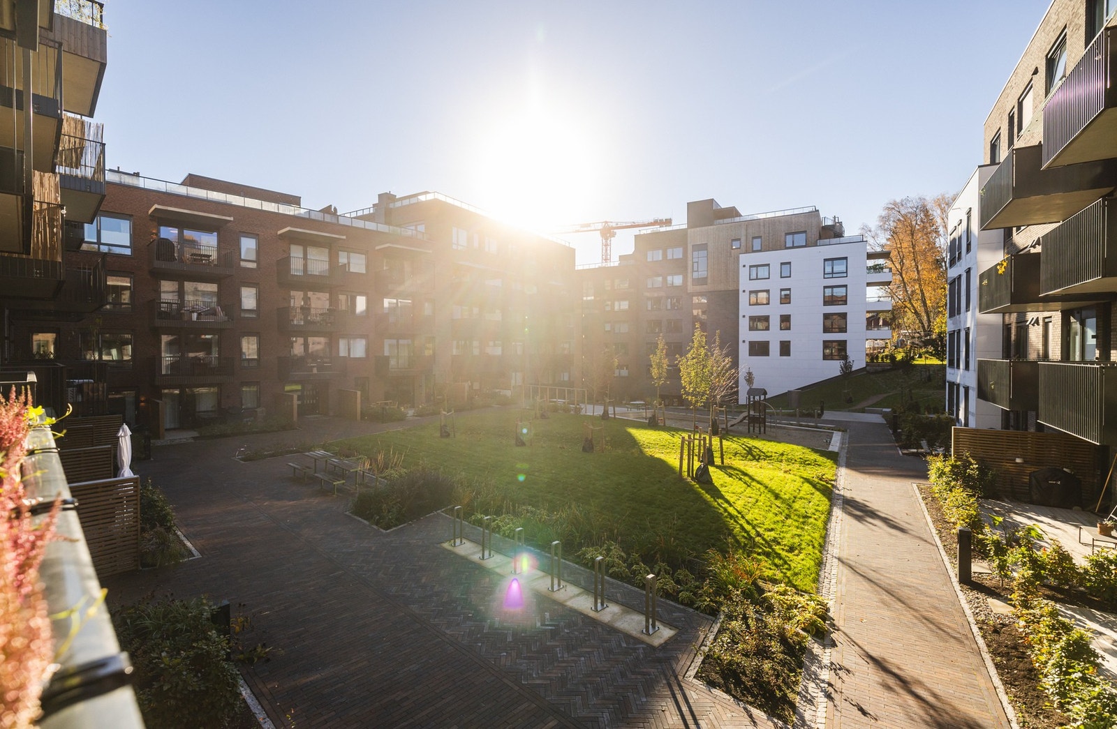 Balkongen vender mot en trivelig bakgård, hvor det er sittegrupper for de voksne og lekeområdet for de minste. Galleribilde