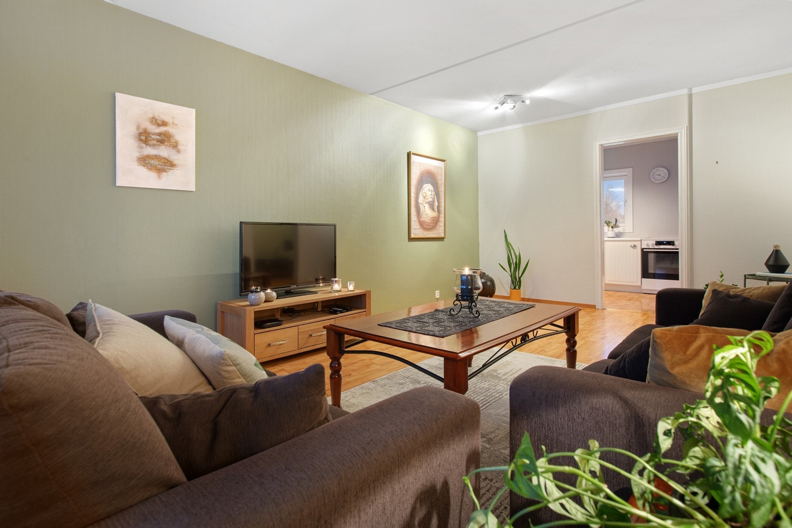 Stuen har malt strietapet på vegger og laminat på gulvet. Galleribilde